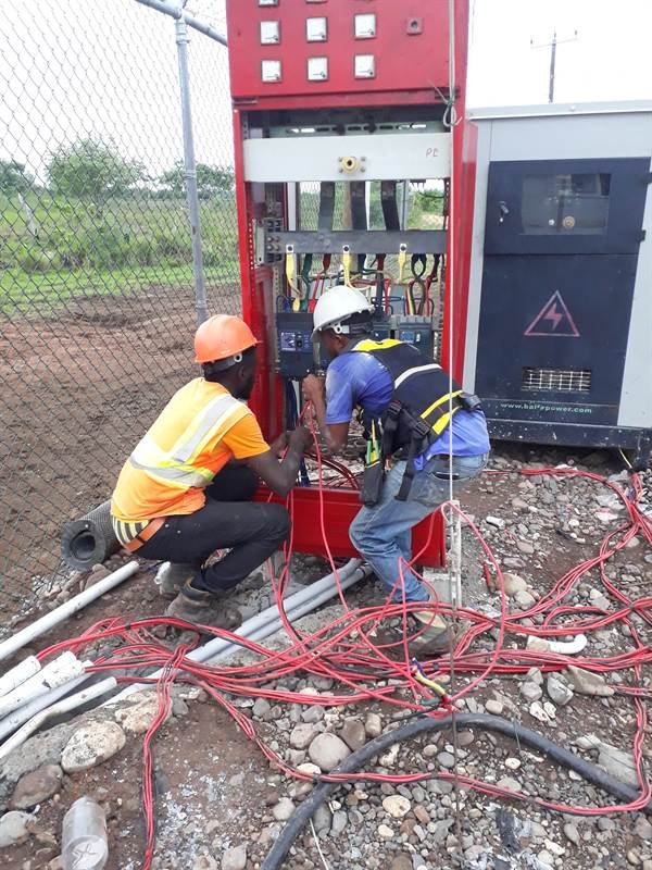 Electricians wiring a substation switchgear cabinet