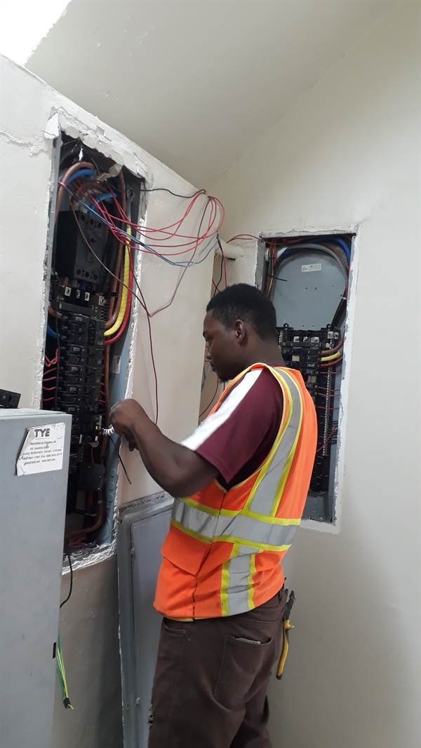 Electrician wiring an electrical panel board