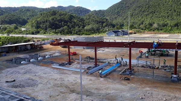 Steel canopy structure under construction along the highway